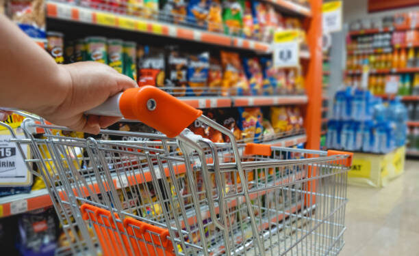 Shopping trolley cart against modern supermarket aisle blurred background