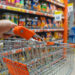 Shopping trolley cart against modern supermarket aisle blurred background